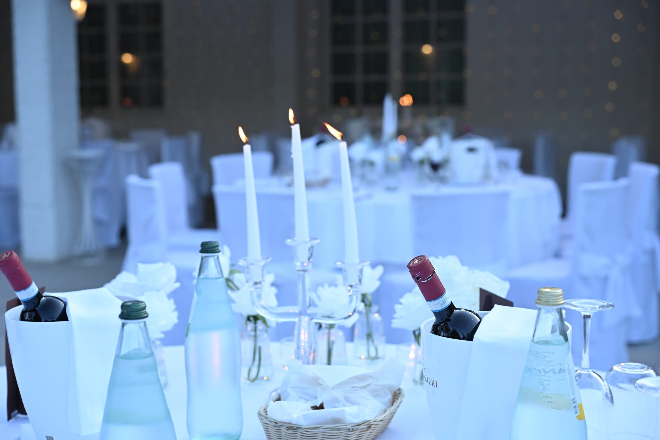 Candele accese e mise en place sui tavoli allestiti all'imbrunire